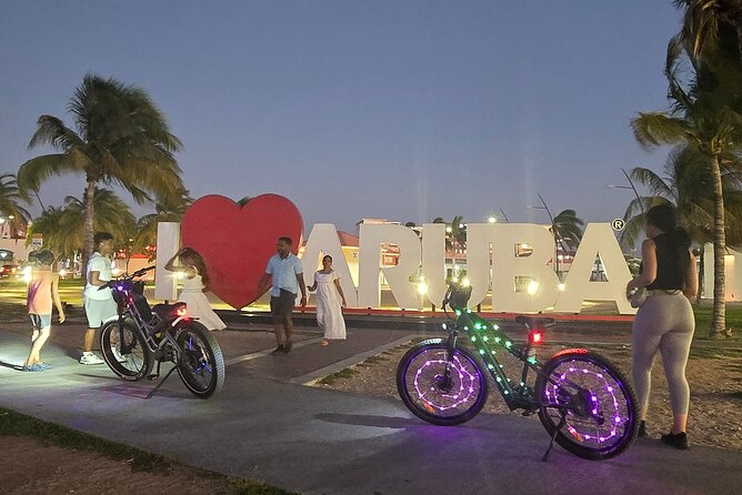 Semi-Private Christmas Edition Twilight Glow E-Bike Oranjestad - Plaza Turismo and the Aruba sign